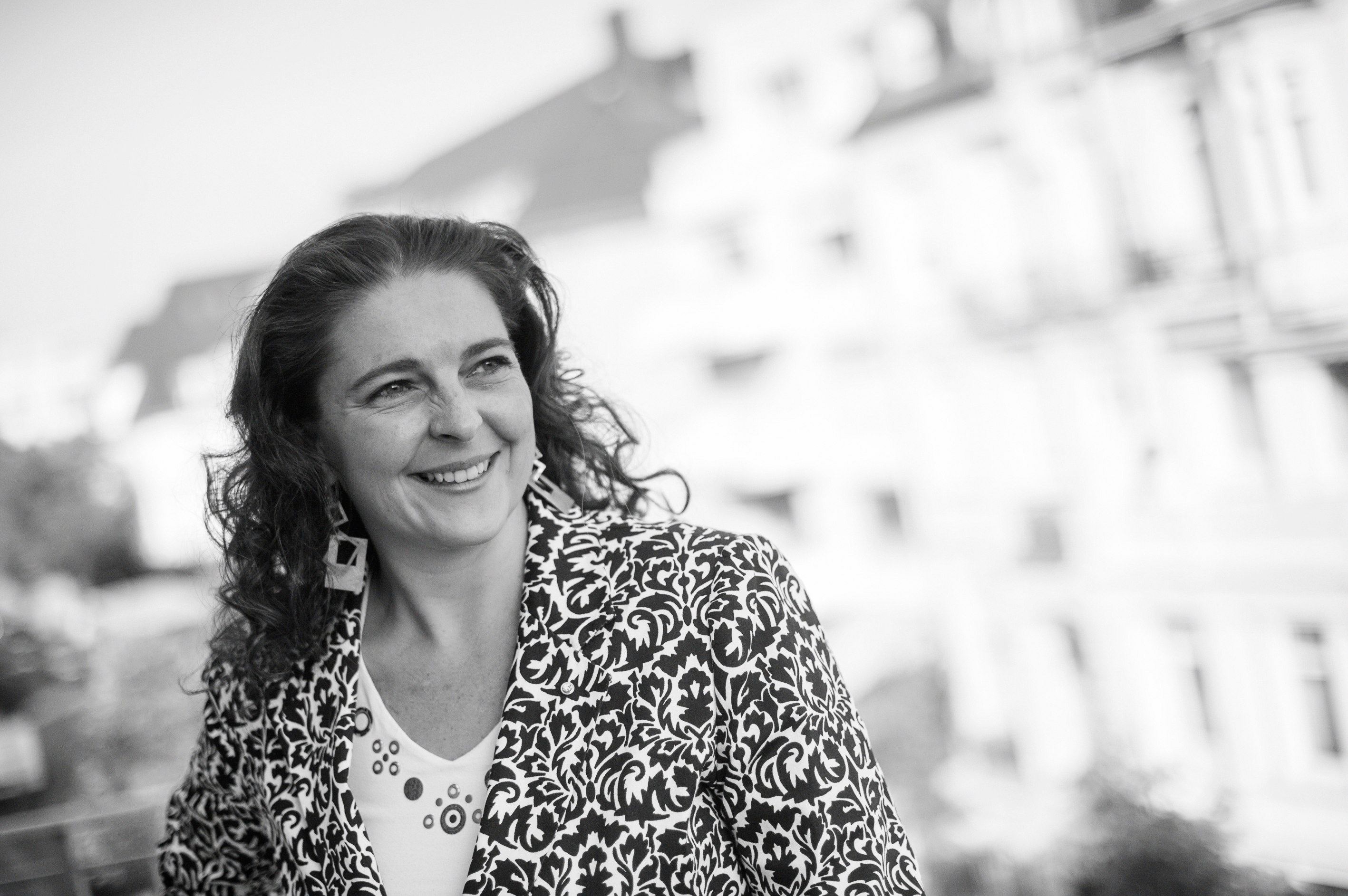 Nathalie Frisch, avocat à la Cour, souriante, en veste à motifs noir et blanc.